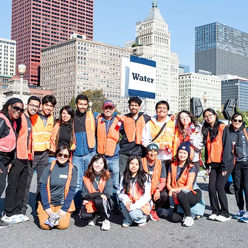 volunteers in orange vest at water station